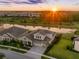 Stunning aerial view of home with pond, lush landscaping, and a beautiful sunset at 7415 Paradiso Dr, Apollo Beach, FL 33572