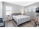 Cozy bedroom with natural light features wood floors, a comfortable bed, and stylish lamps on each nightstand at 7415 Paradiso Dr, Apollo Beach, FL 33572