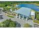 Aerial view of the clubhouse showcasing modern architecture and beautiful lakeside setting near lush greenery and parking at 7415 Paradiso Dr, Apollo Beach, FL 33572