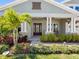Charming front porch adorned with stone pillars, lush landscaping, and a cozy seating area, offering a warm welcome at 7415 Paradiso Dr, Apollo Beach, FL 33572