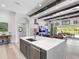 Open-concept living space showcasing a kitchen island, cozy living room with fireplace, and outdoor access to the pool at 7415 Paradiso Dr, Apollo Beach, FL 33572