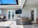 Outdoor kitchen and covered patio featuring a built-in grill, television, and stylish stone flooring at 7415 Paradiso Dr, Apollo Beach, FL 33572