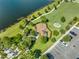 Aerial view of a community playground with modern play equipment near a parking lot and picturesque green space by a lake at 7415 Paradiso Dr, Apollo Beach, FL 33572