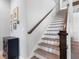 Bright staircase with wood treads, white risers, a dark wood handrail, and a landing with an adjacent cabinet at 7415 Paradiso Dr, Apollo Beach, FL 33572