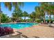 A refreshing community swimming pool surrounded by lounge chairs, vibrant foliage, and brick pavers, ideal for relaxation at 7415 Paradiso Dr, Apollo Beach, FL 33572