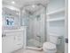 Bathroom featuring a glass shower, white vanity with modern fixtures, toilet and floating shelves at 7932 Sailboat Key S Blvd # 806, South Pasadena, FL 33707