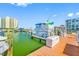 Large boat docked at a wooden slip with a white storage bin, under a clear blue sky at 7932 Sailboat Key S Blvd # 806, South Pasadena, FL 33707