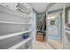 View of walk-in closet featuring custom shelving, storage, and doorway to bathroom at 7932 Sailboat Key S Blvd # 806, South Pasadena, FL 33707