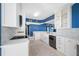 Bright kitchen featuring white cabinets, updated appliances and a backsplash with a view into other rooms at 7932 Sailboat Key S Blvd # 806, South Pasadena, FL 33707