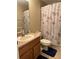 Bathroom featuring shower with Paris-themed curtains, a wood vanity and matching blue rugs at 9613 Jasmine Brook Crk, Land O Lakes, FL 34638