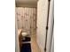 Cozy bathroom featuring a shower with Paris-themed curtains, wood vanity and tile floors at 9613 Jasmine Brook Crk, Land O Lakes, FL 34638