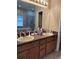 Bathroom featuring double sinks, ample counter space, and a large mirror, a bathtub can be seen in the mirror at 9613 Jasmine Brook Crk, Land O Lakes, FL 34638