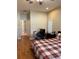 Bright bedroom featuring wood floors, a bed with a red and black comforter, and a desk area at 9613 Jasmine Brook Crk, Land O Lakes, FL 34638