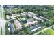 Aerial view of the community with a pool, tennis court, pond, green spaces, and mature trees at 9700 Starkey Rd # 321, Seminole, FL 33777
