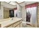 Bright bathroom featuring a shower, large mirror, and charming window with natural light at 10014 118Th Way, Seminole, FL 33772