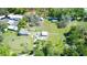 Aerial view of a home on a large lot, offering ample space and featuring mature trees and additional outbuildings at 10034 Burton St, New Port Richey, FL 34654