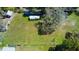 A grassy, fenced-in property with mature trees and additional storage buildings, ideal for outdoor living at 10034 Burton St, New Port Richey, FL 34654
