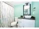 Bright bathroom with modern vanity, vessel sink, decorative mirror, and elegant shower curtain offering a serene space at 10034 Burton St, New Port Richey, FL 34654