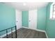 Bedroom with two white doors, hardwood flooring, and blue walls at 10034 Burton St, New Port Richey, FL 34654