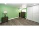 Bedroom with green walls, dark wood furniture, and hardwood flooring at 10034 Burton St, New Port Richey, FL 34654