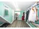 A mint green walk-in closet features hard surface floors and hanging racks at 10034 Burton St, New Port Richey, FL 34654