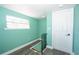 The hallway has a window, grey wood-look flooring, green walls, and an access stairwell at 10034 Burton St, New Port Richey, FL 34654