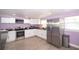 A kitchen offers stainless steel appliances, white cabinetry, and hard surface floors at 10034 Burton St, New Port Richey, FL 34654