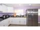 A kitchen features white cabinets, stainless steel appliances, and stone countertops at 10034 Burton St, New Port Richey, FL 34654