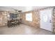 Unique living space with stone walls, wood-look flooring, ceiling fan, and a bright entrance, blending rustic charm with modern appeal at 10034 Burton St, New Port Richey, FL 34654