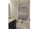 Bathroom featuring granite vanity and shower with gray and white striped curtain at 10240 Meadow Wren Ave, Weeki Wachee, FL 34613