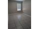 A simple bedroom with tile flooring and a bright window at 10240 Meadow Wren Ave, Weeki Wachee, FL 34613