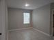 A simple bedroom with tile flooring and a bright window at 10240 Meadow Wren Ave, Weeki Wachee, FL 34613