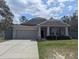 Charming single-story home with gray siding, stone accents, and a well-manicured lawn at 10240 Meadow Wren Ave, Weeki Wachee, FL 34613