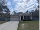 Beautiful single-Gathering home with a lush front lawn, gray exterior, and classic design elements at 10240 Meadow Wren Ave, Weeki Wachee, FL 34613