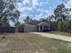 Charming single-story home with gray siding, stone accents, and a well-manicured lawn at 10240 Meadow Wren Ave, Weeki Wachee, FL 34613