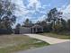 Charming single-story home with gray siding, stone accents, and a well-manicured lawn at 10240 Meadow Wren Ave, Weeki Wachee, FL 34613