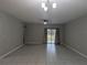 Large living room with tiled floors, a ceiling fan, and sliding glass doors at 10240 Meadow Wren Ave, Weeki Wachee, FL 34613