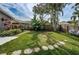 Expansive backyard featuring lush green grass, stone path and privacy fence, perfect for outdoor activities at 1031 Ridge View Ln, Palm Harbor, FL 34683