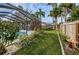 Relax in this lush backyard featuring a screened-in pool area and tropical landscaping at 1031 Ridge View Ln, Palm Harbor, FL 34683