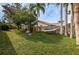 Beautiful backyard featuring lush green grass, mature trees and hammock, perfect for outdoor relaxation at 1031 Ridge View Ln, Palm Harbor, FL 34683