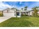 Charming single-story home featuring a well-manicured lawn and tropical landscaping at 1031 Ridge View Ln, Palm Harbor, FL 34683