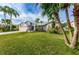Picture of a charming single-Gathering home with a lush green lawn and mature palm trees at 1031 Ridge View Ln, Palm Harbor, FL 34683