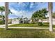 Inviting single-Gathering home showcasing lush green lawn and mature palm trees at 1031 Ridge View Ln, Palm Harbor, FL 34683