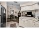 Open concept kitchen features white cabinetry, stainless steel appliances, and flows seamlessly into the dining and living areas at 1031 Ridge View Ln, Palm Harbor, FL 34683