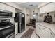 Well-lit kitchen features stainless steel appliances, including a range and refrigerator, with white cabinetry for ample storage at 1031 Ridge View Ln, Palm Harbor, FL 34683