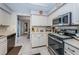 Modern kitchen with stainless steel appliances, white cabinets, and tile backsplash at 1031 Ridge View Ln, Palm Harbor, FL 34683