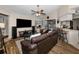 Spacious living room with a ceiling fan, large TV, and comfortable seating, seamlessly connected to the kitchen and outdoor patio at 1031 Ridge View Ln, Palm Harbor, FL 34683
