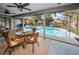 Inviting screened-in pool area with outdoor seating, lush landscaping, and clear blue water at 1031 Ridge View Ln, Palm Harbor, FL 34683