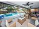 Inviting pool area with comfortable seating and ceiling fans, perfect for relaxing and entertaining at 1031 Ridge View Ln, Palm Harbor, FL 34683