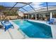 Beautiful screened-in pool area boasts crystal-clear water and ample seating for enjoying sunny days outdoors at 1031 Ridge View Ln, Palm Harbor, FL 34683